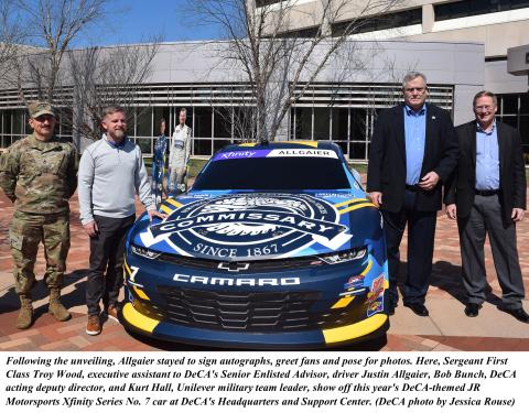Photo of staff during the unveiling of the DeCA logo on a simulator replica of the No. 7 Chevrolet driven by NASCAR driver Justin Allgaier 
